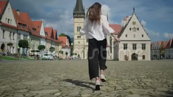在斯洛伐克巴尔德乔夫市政厅广场跑步的兴奋女孩视频的预览图