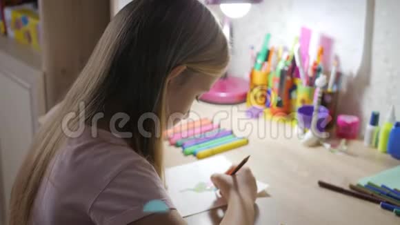 小女孩在灯光下在桌子上做作业视频的预览图