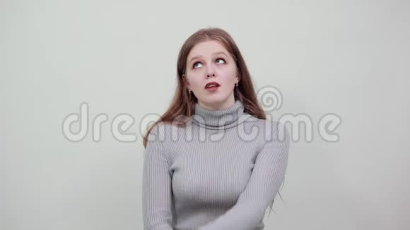 背景上穿灰色毛衣的年轻女子用食指做手势视频的预览图