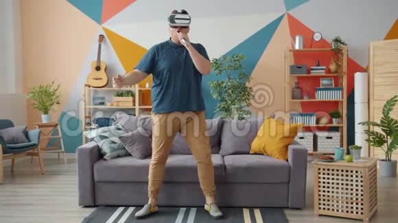 在家戴着虚拟现实眼镜在遥控中唱歌的有创意的人视频的预览图