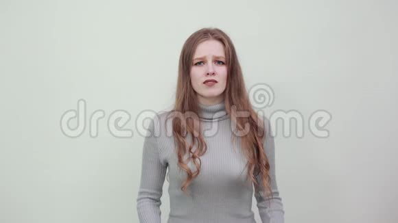 一个年轻漂亮的红发女子穿着灰色毛衣表情惊恐视频的预览图