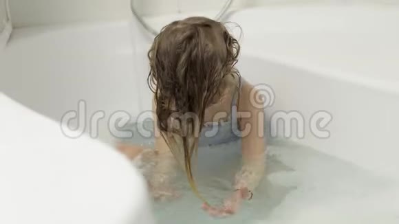 可爱的金发女孩穿着泳装洗澡小孩子洗头视频的预览图