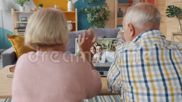 退休夫妇在网上打视频电话在家里和年轻人交谈视频的预览图