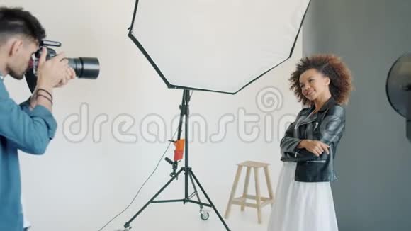 有魅力的女人在摄影棚里摆姿势摄影师在拍照视频的预览图