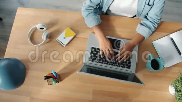 美国黑人自由职业者在木桌上用笔记本电脑打字的最大视角视频的预览图