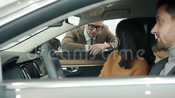 销售经理与年轻的家庭妇女男子和儿童交谈购买汽车视频的预览图