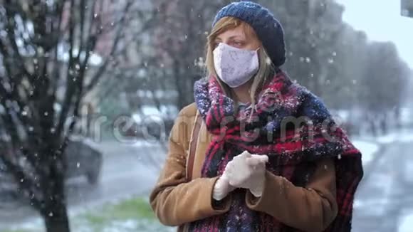 街上戴防护面罩和手套的妇女的冬季画像视频的预览图
