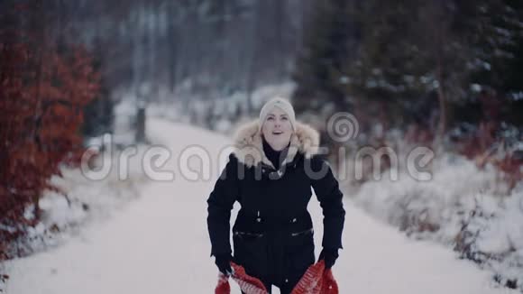 积极的女人在雪地上跳跃在冬天玩围巾视频的预览图