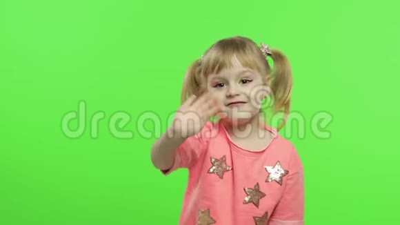 穿着粉红色衬衫的积极孩子挥舞着她的手说了些什么色度键视频的预览图
