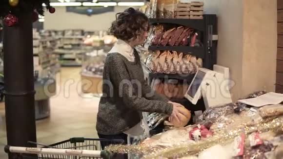 一个女孩在超市的电子秤上称重柚子并贴上一张标价的贴纸网格包中的柚子视频的预览图