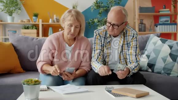 退休的男人和女人在家看财务文件视频的预览图