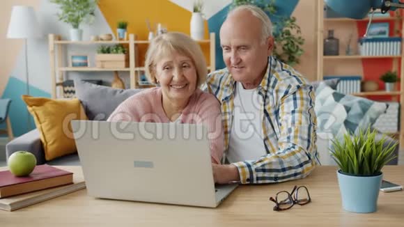 一对老夫妇在家用电脑聊天打字享受互联网内容视频的预览图