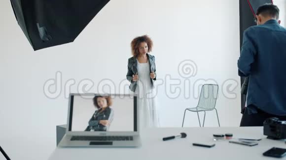 一位美丽的年轻女士在摄影棚与摄影师合影时摆姿势拍照视频的预览图
