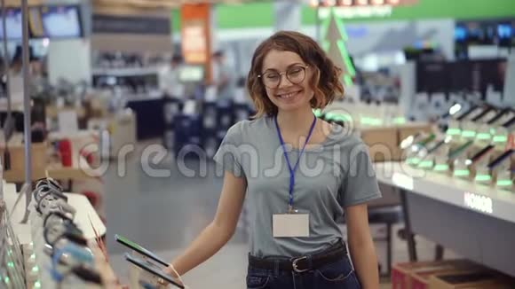 超市商店正面女性卖家或店员画像穿着蓝色衬衫和空徽章的女人视频的预览图