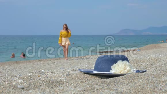 在沙滩上休息的女士在鹅卵石海滩上举行稻草时尚帽子的培训课程视频的预览图