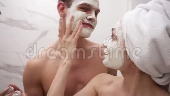 快乐积极的年轻夫妇在淋浴后站在浴室里玩得开心两者都在玩视频的预览图