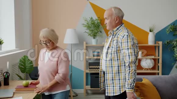 退休男子送礼物盒给家里心爱的幸福女人的慢动作视频的预览图