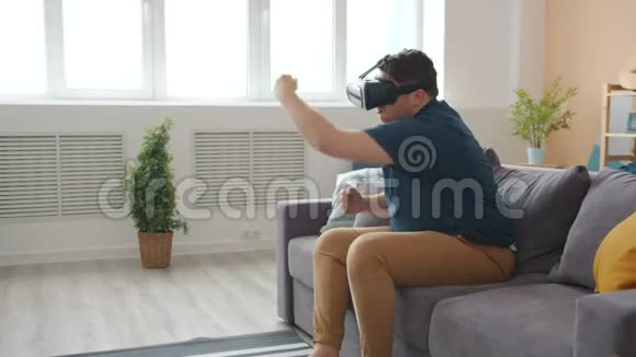 快乐的年轻人玩拳击戴着虚拟现实的眼镜视频的预览图