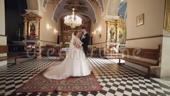 新婚夫妇白人新娘和新郎一起在一个古老的教堂里婚礼视频的预览图