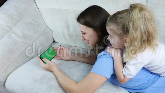 带小孩的女人用5g全屏手机观看视频视频的预览图