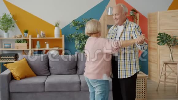在家跳舞的高级男女慢动作手握音乐视频的预览图