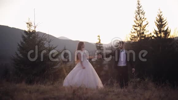 新婚夫妇白人新郎和新娘在山坡上跳舞新婚夫妇视频的预览图
