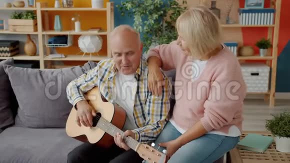 老夫妻在家唱歌男人在家弹吉他享受音乐视频的预览图