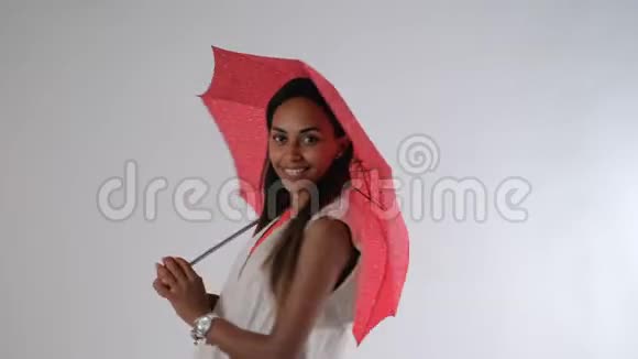 漂亮的非洲模特用雨伞摆姿势拍摄时尚杂志照片视频的预览图