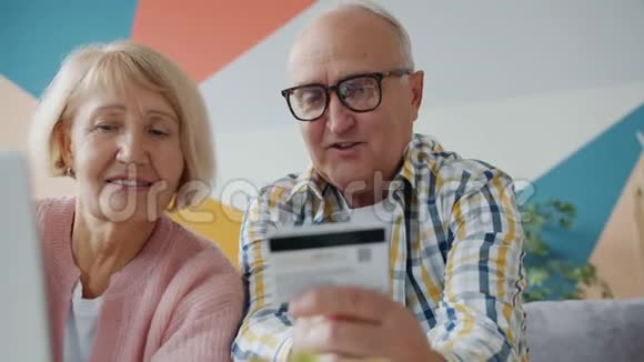 使用笔记本电脑上网购物的老年男女视频的预览图