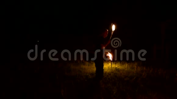 黑暗中缓慢的人转动着燃烧的球低调消防表演特写镜头视频的预览图