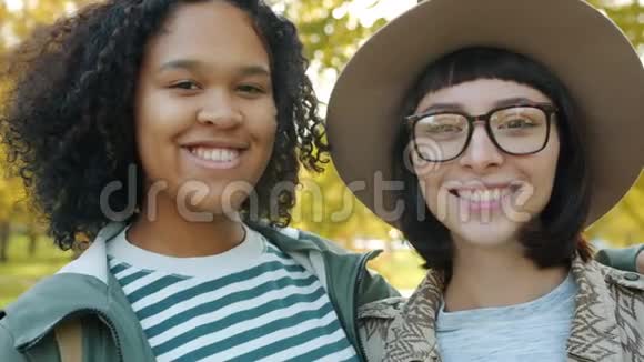 美国黑人和白人美女在户外微笑的特写照片视频的预览图