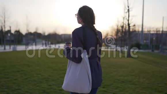 日落时分一个穿着西装的棉花袋的迷人女人无塑料废物的健康生活方式的概念视频的预览图