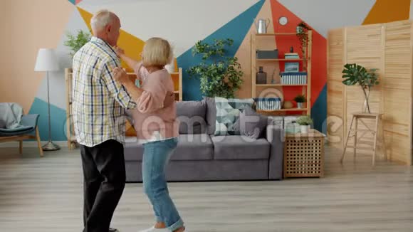 欢快的老夫妇在家跳舞手牵着手微笑着说话视频的预览图