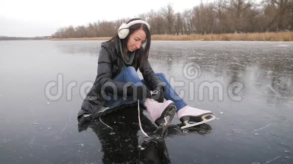 穿着手套的女孩在溜冰场系鞋带视频的预览图