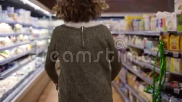 罕见的幸福兴奋的女人穿着毛衣去购物与手推车走了一排快乐地跳跃慢慢视频的预览图