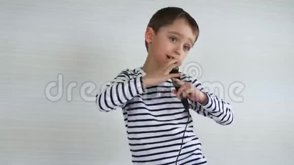 一个小男孩手里拿着麦克风唱着一首歌扮演歌手孩子体验快乐的情绪视频的预览图