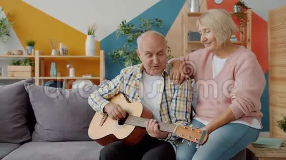 退休夫妇在家里弹吉他唱歌享受浪漫的一天视频的预览图