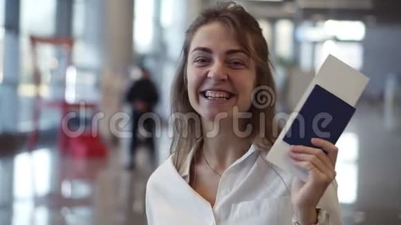 快乐美丽的美国女人的肖像带着机票挥舞着护照在寻找和打击视频的预览图