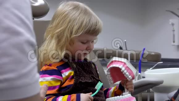 小女孩在玩下巴模型的时候学习如何清洁牙齿视频的预览图