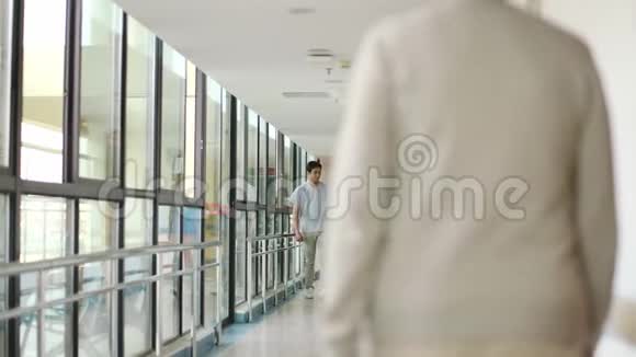 亚洲医疗保健专业人员在医疗设施走廊行走视频的预览图