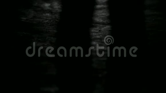 黑暗暴露的轮廓一个女人从后面的视线在离焦一个女人正沿着黑暗的走廊走着视频的预览图