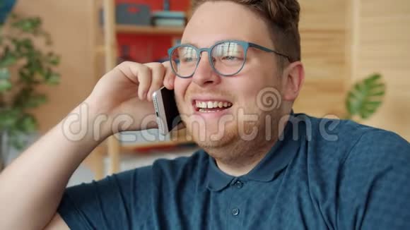 有魅力的男人在手机上说话时动作缓慢微笑着在家笑视频的预览图
