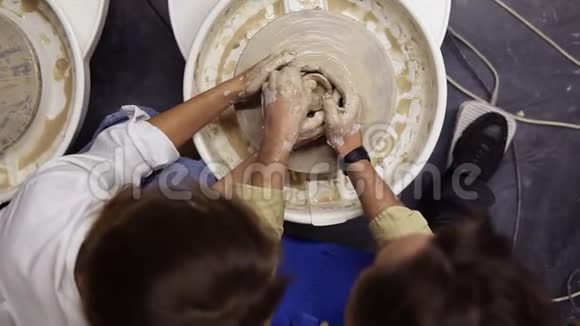 从浪漫情侣肮脏的双手上方拍摄的照片他们一起在陶工轮上工作一起雕刻陶罐视频的预览图