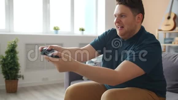快乐的年轻人在家玩电子游戏赢得接吻操纵杆玩得开心视频的预览图