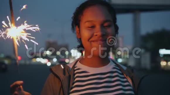 吸引人的非裔美国女孩夜间在户外手持孟加拉灯的肖像视频的预览图