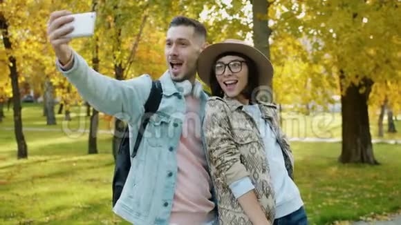 公园里一对欢快的情侣自拍的画像竖起大拇指笑着视频的预览图