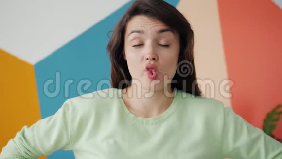 一个开朗的黑发女人独自在室内嬉戏的滑稽面孔视频的预览图
