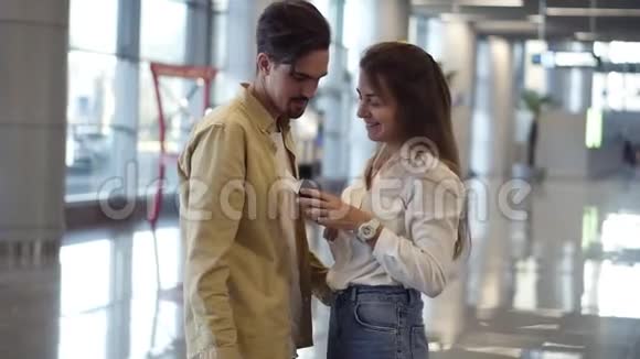 令人兴奋的是在机场向男友出示带有签证印章的护照的妇女快乐的一对拥抱他的男人视频的预览图