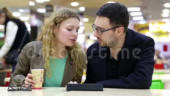 年轻夫妇在咖啡店使用平板电脑视频的预览图
