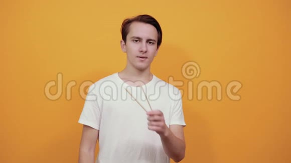 一位身穿白色t恤的年轻人展示了一双大食指和中国筷子视频的预览图